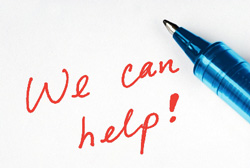 Pen next to a piece of paper with “We Can Help” written on it
