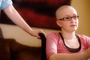 A child with no hair sits in wheelchair